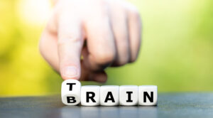 Dice with letters that form the words train and brain, representing what Neurofeedback does for you