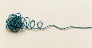 Knotted teal thread gradually untangling into a smooth line, symbolizing healing from unresolved trauma.